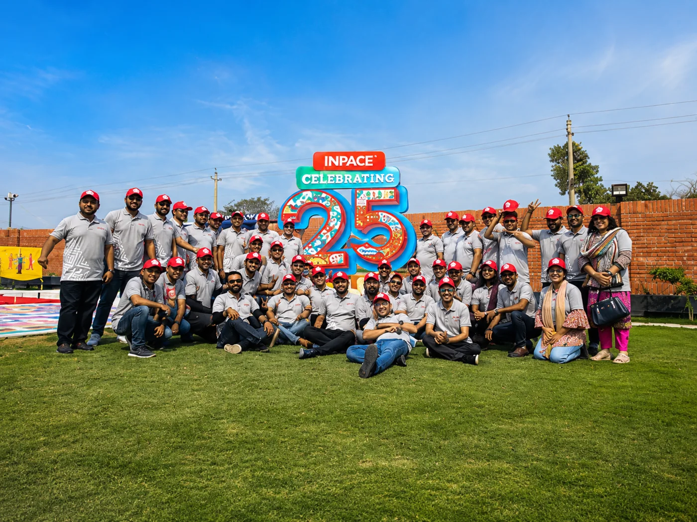 Inpace team gathered around a large 25th anniversary installation.